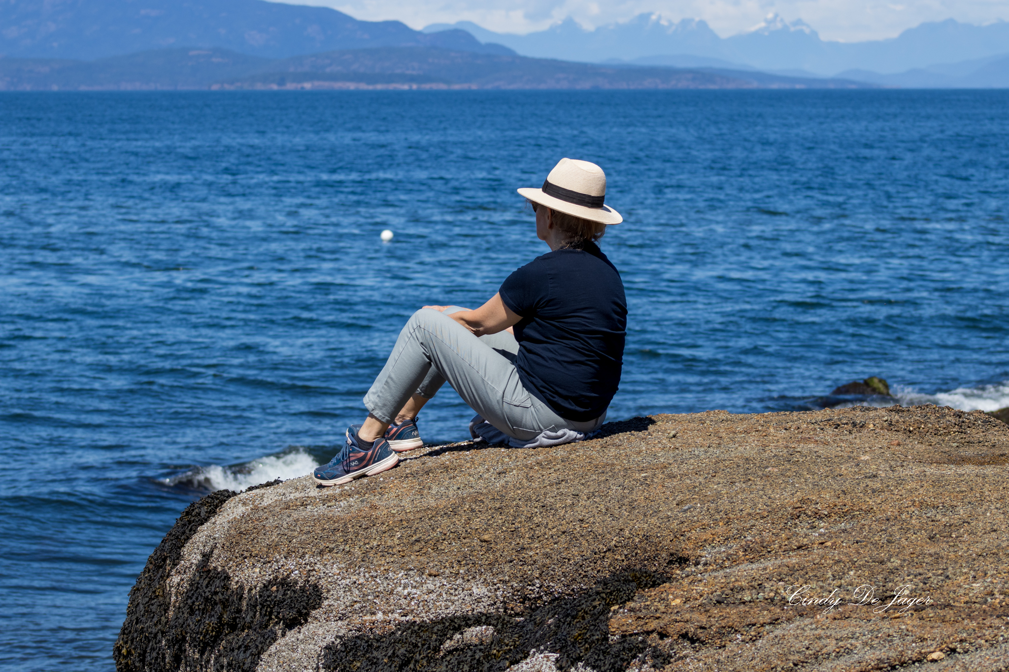 A figure on the rocks, open water ahead — a composition shaped by stillness and west‑coast light.